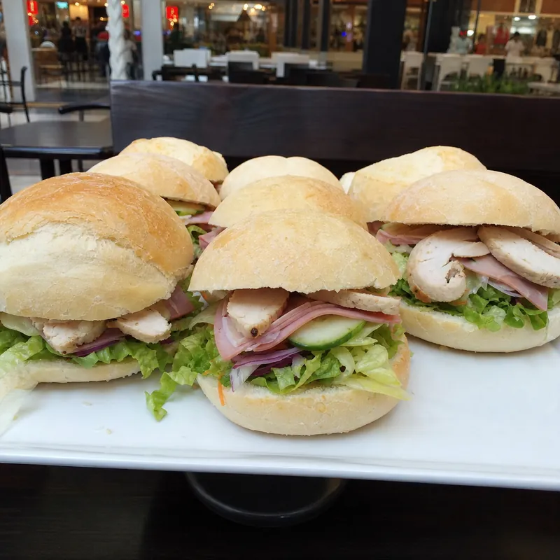 Filled bread rolls on a plate at a cafe table